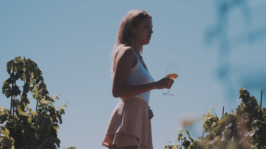 Mujer tomando vino blanco en verano