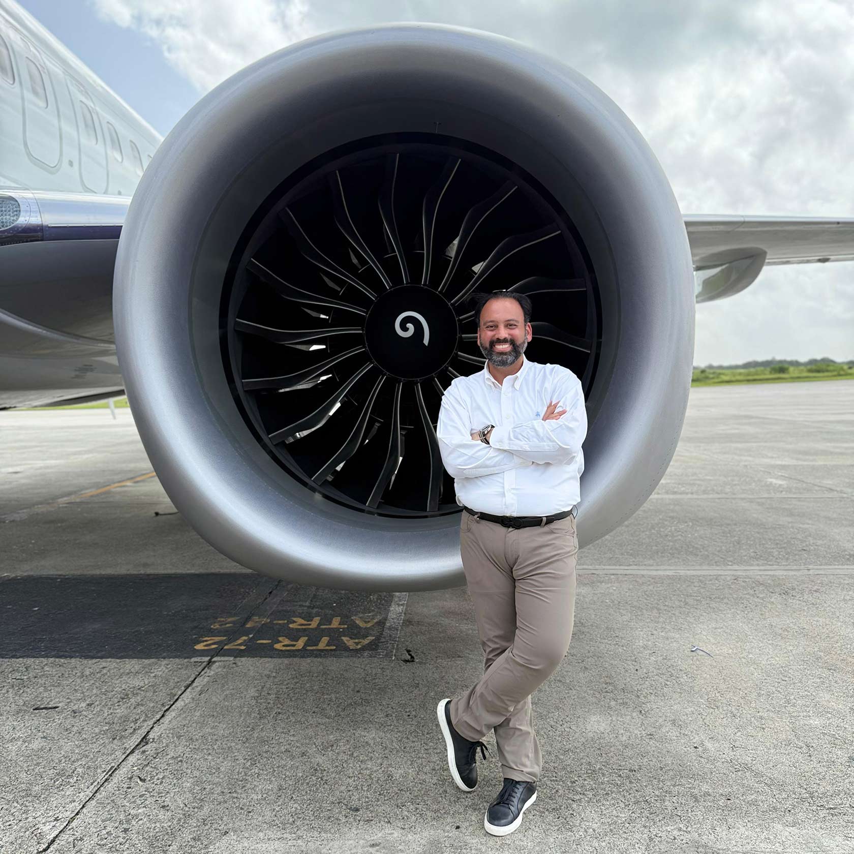 José Gregorio Cabrera Cuello, vicepresidente de Comunicaciones de Arajet, posando frente a la turbina de uno de los nuevos aviones Boeing 737 MAX 8 de la compañía